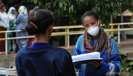 Women with an N-95 masks speaks with a girl in Ethiopia
