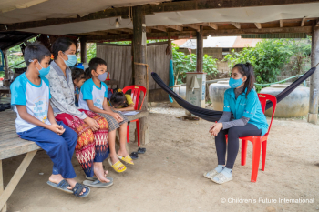 A social worker speaks with a family in Cambodia.