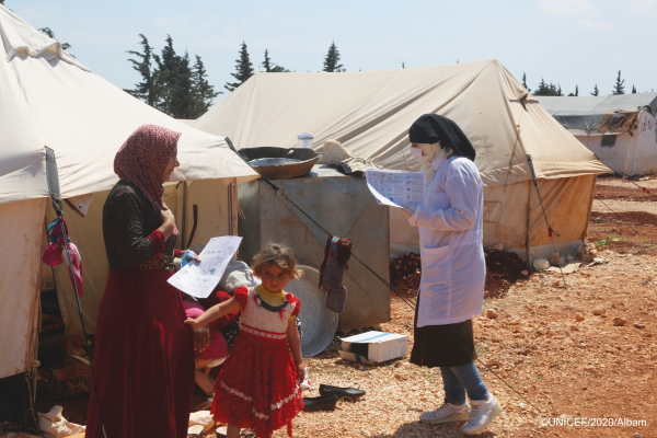 Image of worker assisting family in Syria