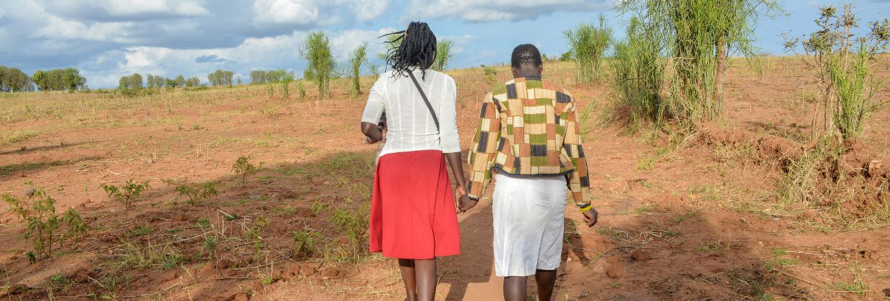 Image of a social worker walking with a young girl in Uganda